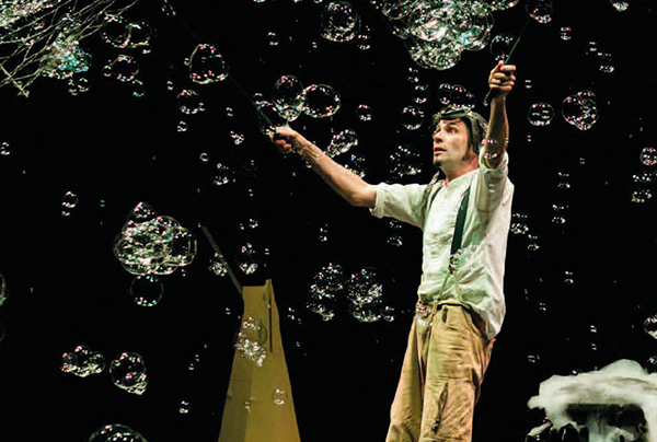 immagine di scena con l'attore Michele Cafaggi con grandi bolle di sapone 