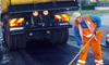un camion e un operatore che asfalta una strada