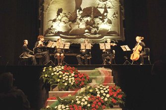 concerto al teatro alle vigne: la scalinata con fiori tricolori e i musicisti sul palco